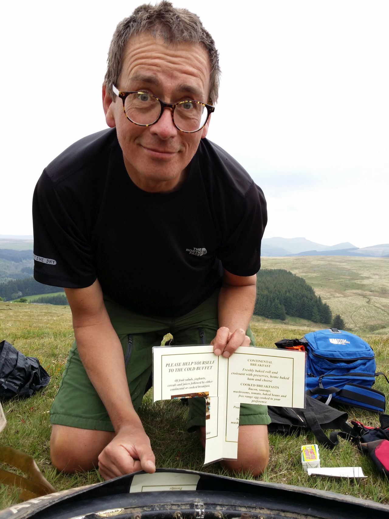 Day 7 - Trailside repair novelty ... having run out of tyre boots improvising On slopes of Cefn y Ystrad with laminated menu after Paul`s tyre splits again! © Paul Bonwick